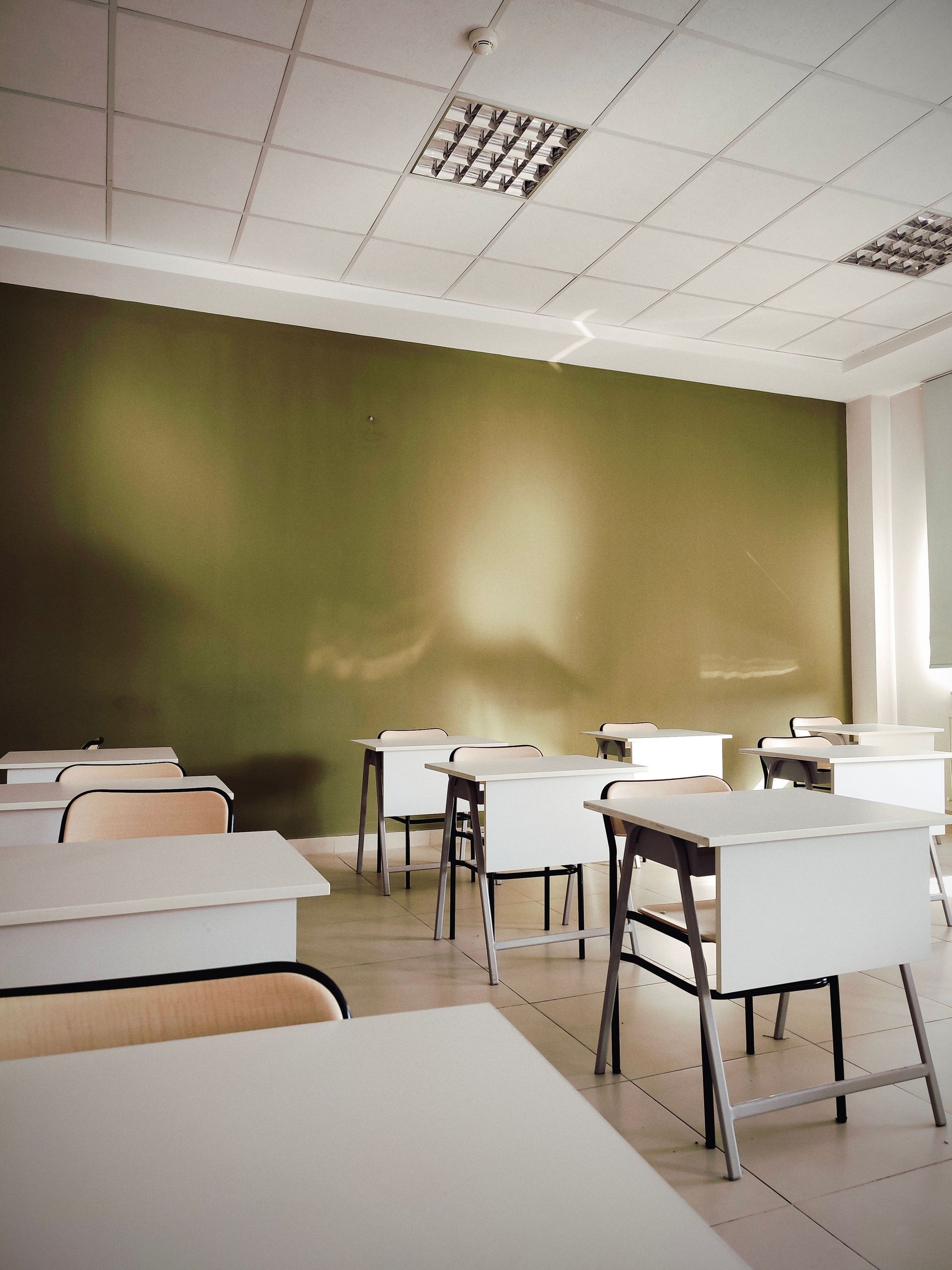 Modern classroom interior with desks and chairs, showcasing clean design and ample natural light.